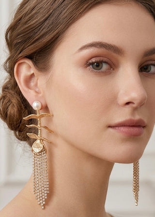 Close-up of a woman wearing gold earrings with pearl accents.