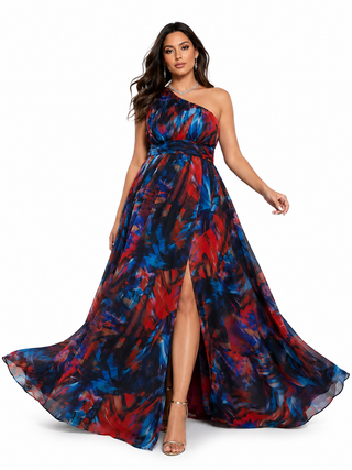 A woman modeling a one-shoulder floor-length gown with a red, blue, and black abstract print, set against a plain white background.