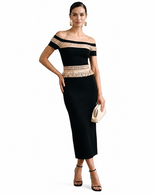 Woman wearing a black off-shoulder dress with beige lace details on a white background