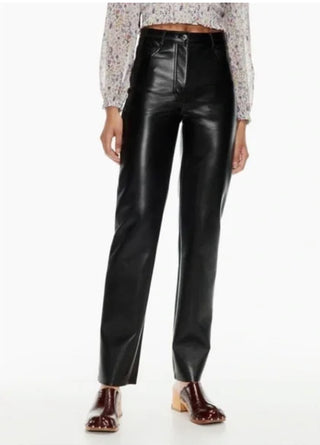 Black leather pants worn by a person on a white background