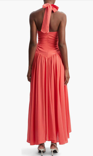 Coral halter neck dress with a bow detail on a white background