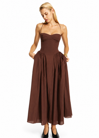 Woman wearing a brown strapless dress on a white background