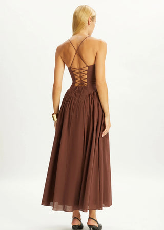 Woman wearing a brown dress with a lace-up back on a white background