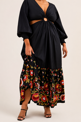 Black top with cut-out design and floral skirt on a plain background