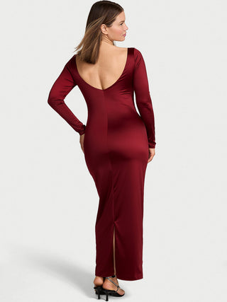 Woman wearing a burgundy evening gown with a backless design on a white background