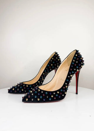A pair of black pointed-toe stiletto pumps covered in iridescent rhinestones and topped with silver spikes, featuring the signature red Christian Louboutin sole, photographed on a white surface against a white background.