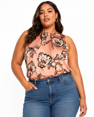 Woman wearing a floral halter top and blue jeans on a white background