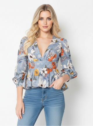 Woman wearing a floral blouse and blue jeans on a white background
