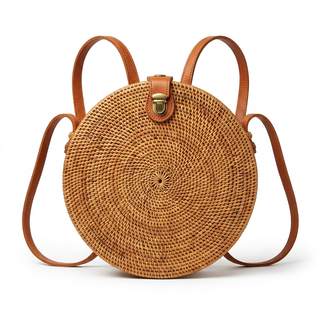 Round woven bag with brown leather straps on a white background
