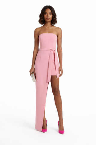 Woman wearing a pink strapless jumpsuit on a white background