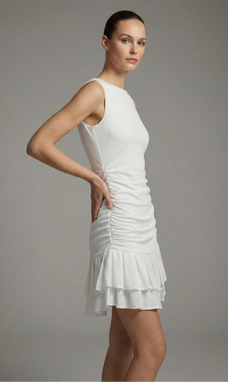 Woman wearing a white dress against a gray background