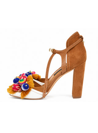 A tan suede high-heeled sandal with a white toe box, colorful embroidered details, and a gold-tone buckle on the T-strap, shown against a plain white background.