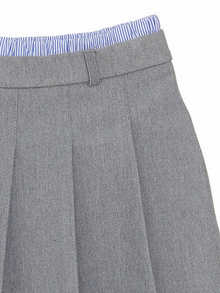 Gray pleated skirt with a blue and white striped top on a white background