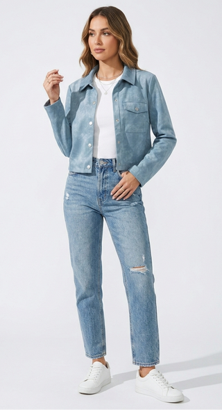 Woman wearing a light blue denim jacket and jeans on a white background