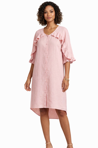 Woman wearing a pink dress with ruffled sleeves on a white background