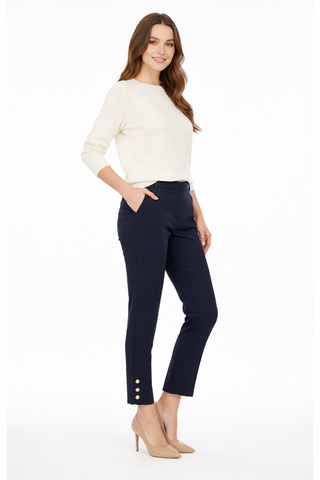 Woman wearing a white top and navy pants with buttons on a white background
