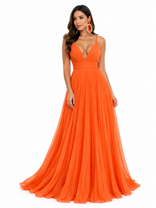 A woman modeling a bright orange floor-length gown with a deep V-neckline, thin shoulder straps, and a flowing chiffon-like skirt against a plain white background.