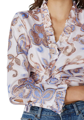 Woman wearing a patterned blouse with floral designs on a white background