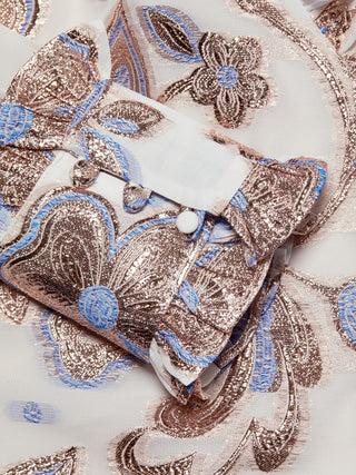 Decorative fabric with intricate patterns and a white bow on a beige background
