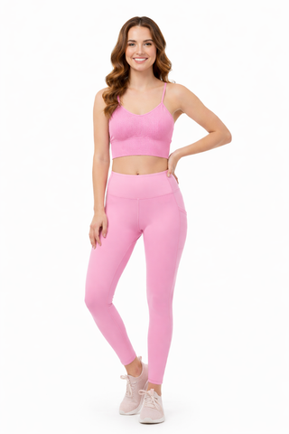 Woman wearing a pink athletic outfit on a white background