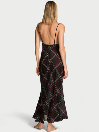 Woman wearing a black plaid dress with thin straps on a white background