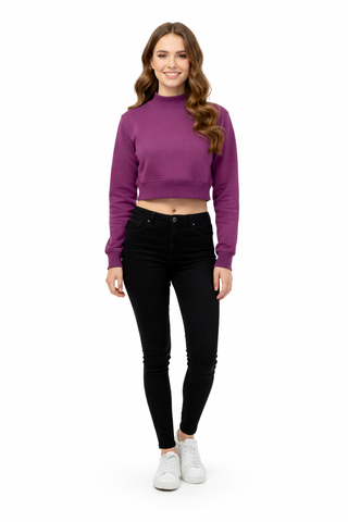Woman wearing a purple cropped sweater and black pants on a white background
