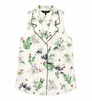 A sleeveless button-front pajama top with a tropical bird and floral print on an off-white background, featuring black piping along the collar, front placket, and hem.