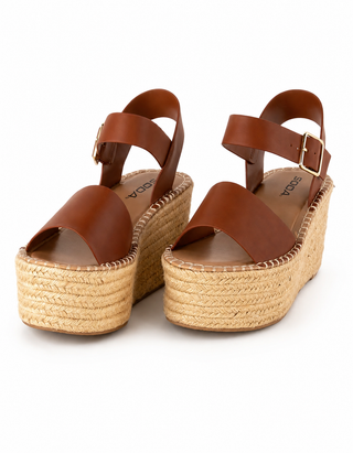 A pair of brown leather platform espadrille sandals with adjustable ankle straps and gold-tone buckles, shown on a clean white background.
