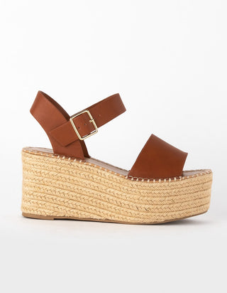 A single brown platform wedge sandal with an ankle strap and gold buckle, shown in a side profile on a light gray background.