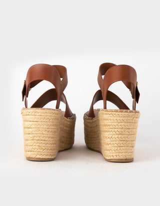 A pair of women's platform espadrille sandals shown from the back, featuring tan leather straps and a natural beige woven jute heel and platform.