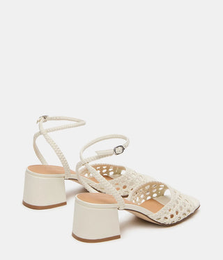 A pair of off-white woven strappy sandals with block heels and square toes, shown from a three-quarters angle on a light gray background.