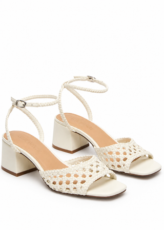 A pair of off-white woven leather block-heel sandals with ankle straps and openwork toe straps, shown on a plain white background.