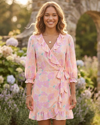 Woman wearing a pink floral dress standing in a garden