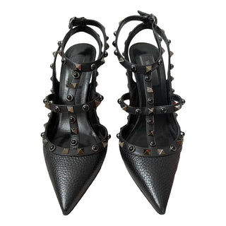 A pair of black pointed-toe slingback heels with multiple straps and pyramid stud embellishments, shown against a plain white background.