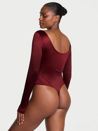 Model wearing a burgundy bodysuit against a plain background